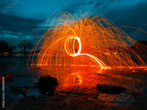 light lines of steel wool with long exposure, speed motion abstract background in the dark night