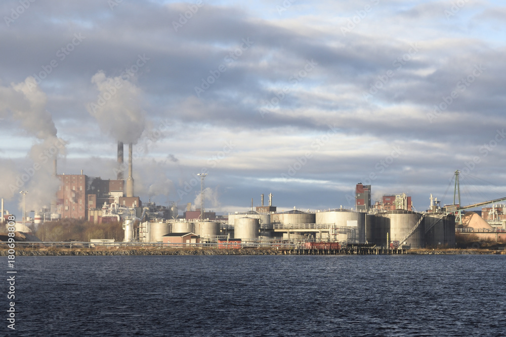 Naklejka premium Pulp factory with lot of smoke comming out of chimneys