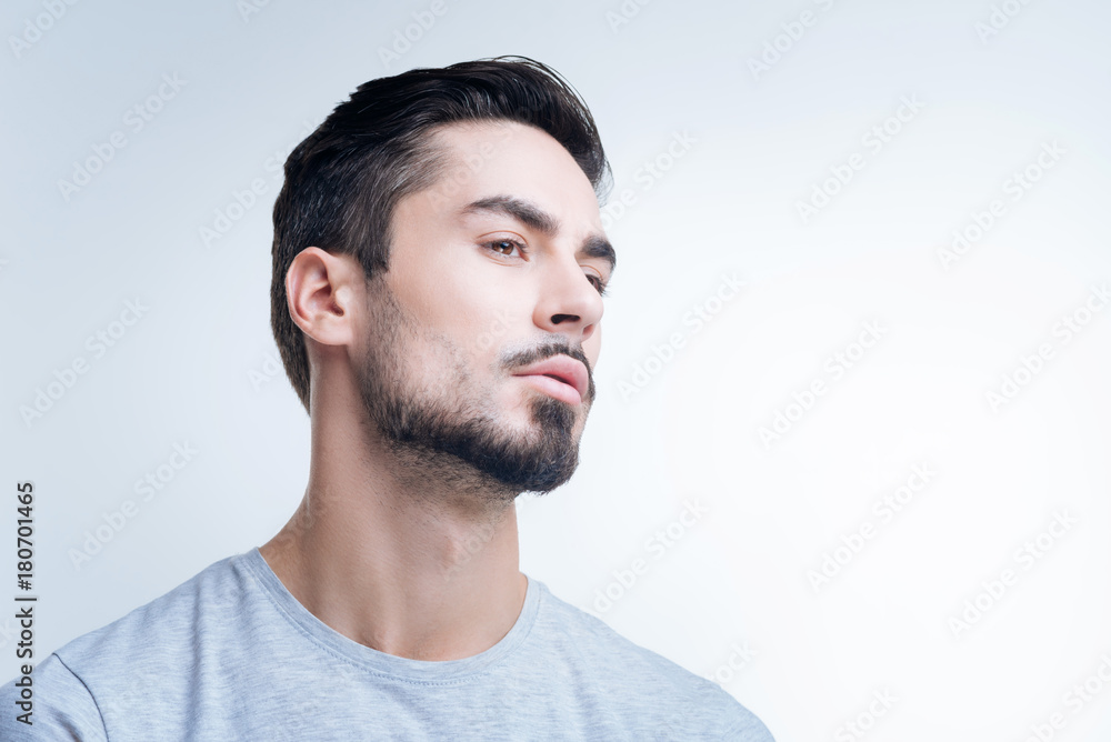 Fototapeta premium Arrogant person. Serious strict arrogant person showing no interest in communicating with other people while standing alone and looking thoughtful