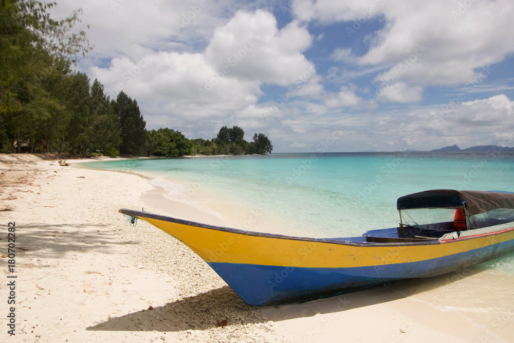 part of a small boat berthed on a tropical beach in raja ampat archipelago