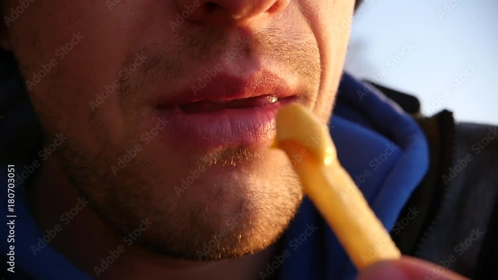 A man is eating tasty hot fries with sauce, close-up. 1920x1080, full hd A man is eating tasty hot fries with sauce, close-up. 1920x1080, full hd
