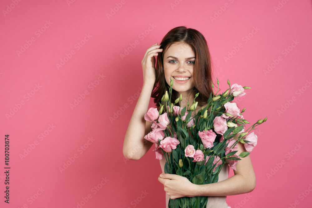 girl with a bouquet of flowers smiling on a pink background girl with a bouquet of flowers smiling on a pink background