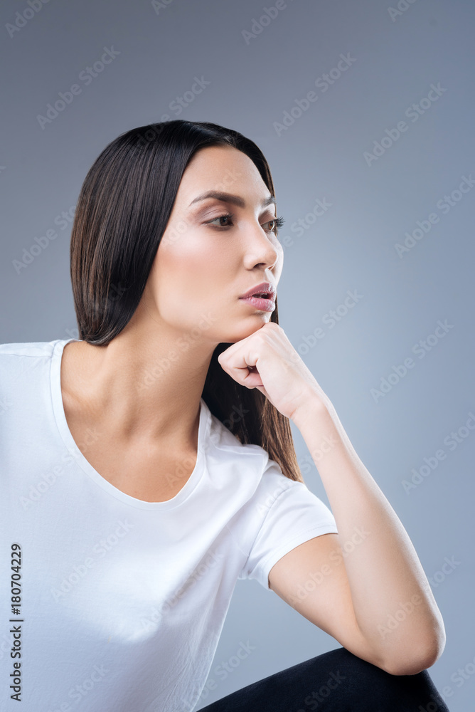 Strong housewife. Enthusiastic reliable strong woman sitting thoughtfully with her chin resting on her fist while preparing to clean the house Strong housewife. Enthusiastic reliable strong woman sitting thoughtfully with her chin resting on her fist while preparing to clean the house