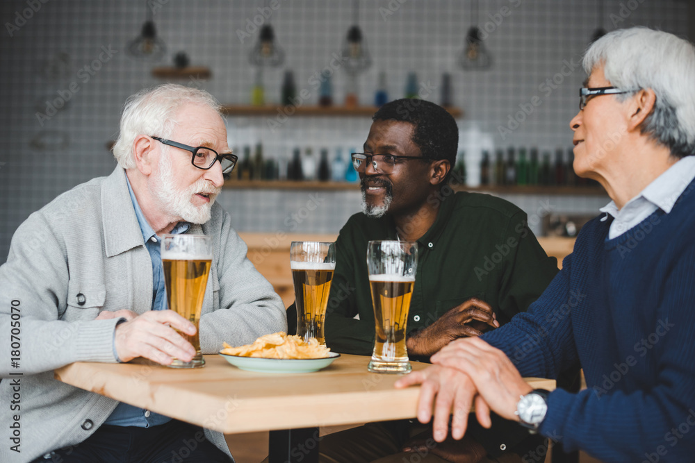 senior friends drinking beer in bar