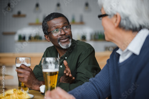 senior friends talking and drinking beer