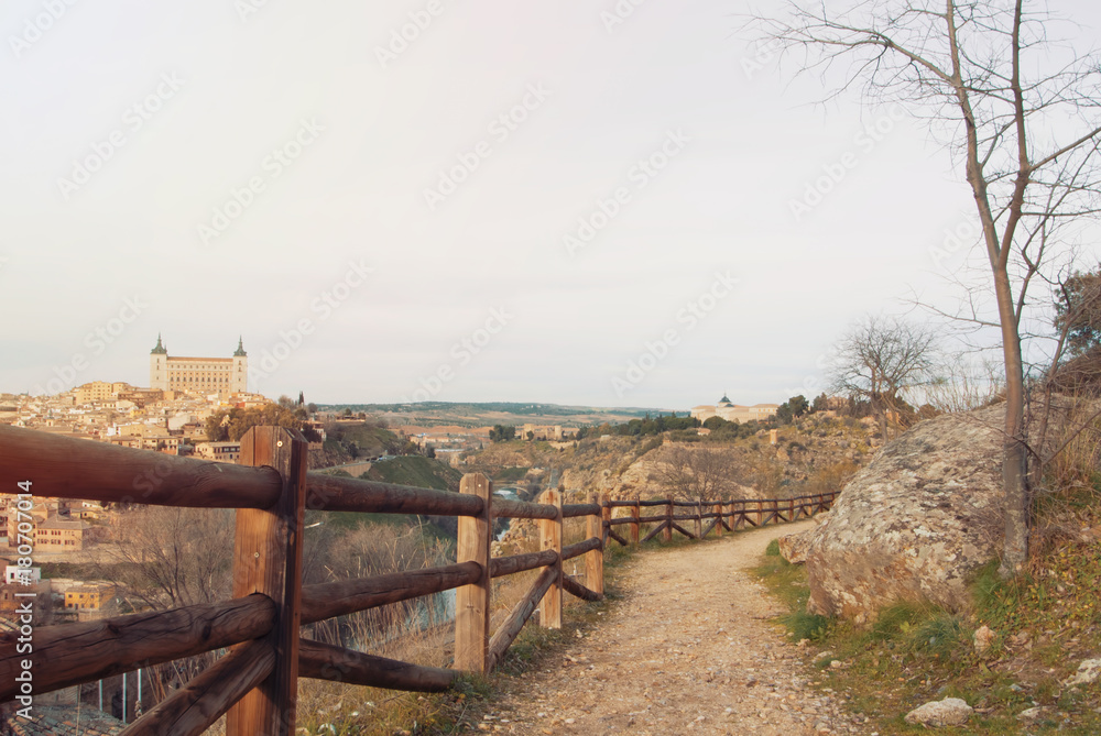 Φωτογραφία A path with wooden rural fence over the hill with a view to Toledo Alcazar, evening at surroundings of Toledo, Castilla la Mancha, Spain