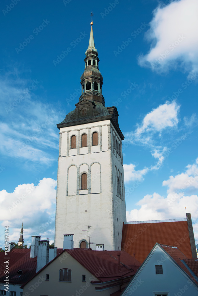Saint Nicholas Church over red tiled roofs at Tallinn, Estonia in the evening.
