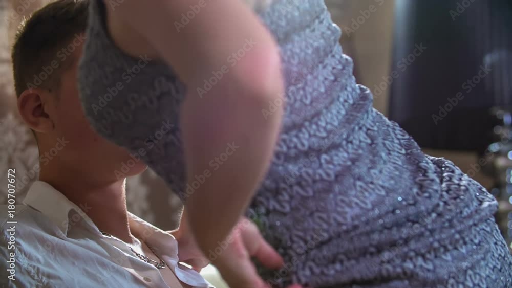 A sexy woman comes and she sits down on her boyfriend's lap. Then they start touching. 