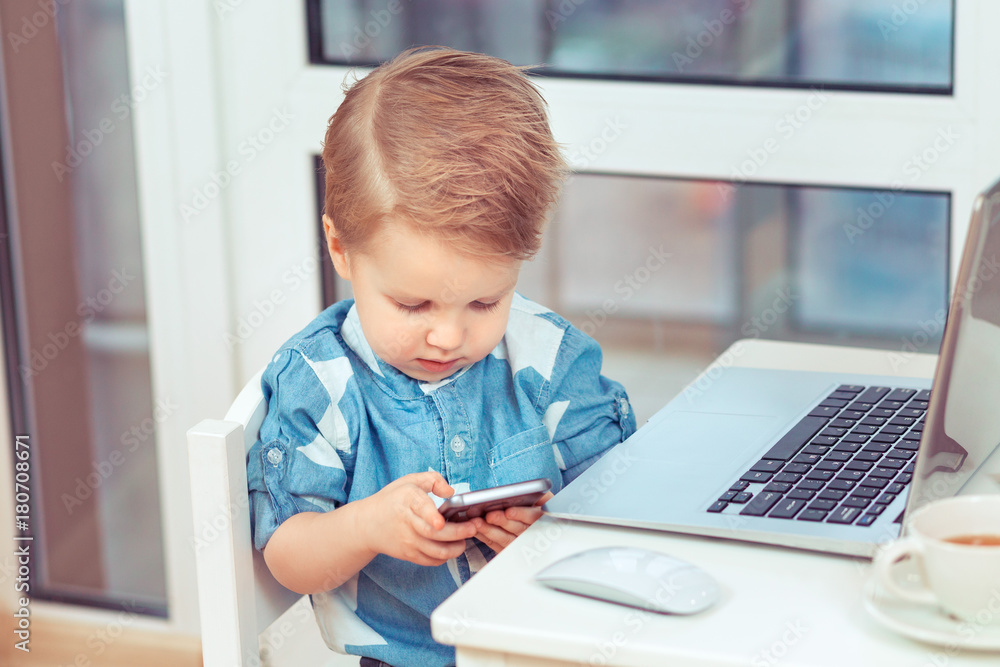 baby boy playing with mobile phone. new digital technologies in the hands of a child. Portrait of toddler with smartphone baby boy playing with mobile phone. new digital technologies in the hands of a child. Portrait of toddler with smartphone