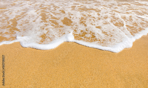 foamy wave fine sand and sunshine reflection on the beach