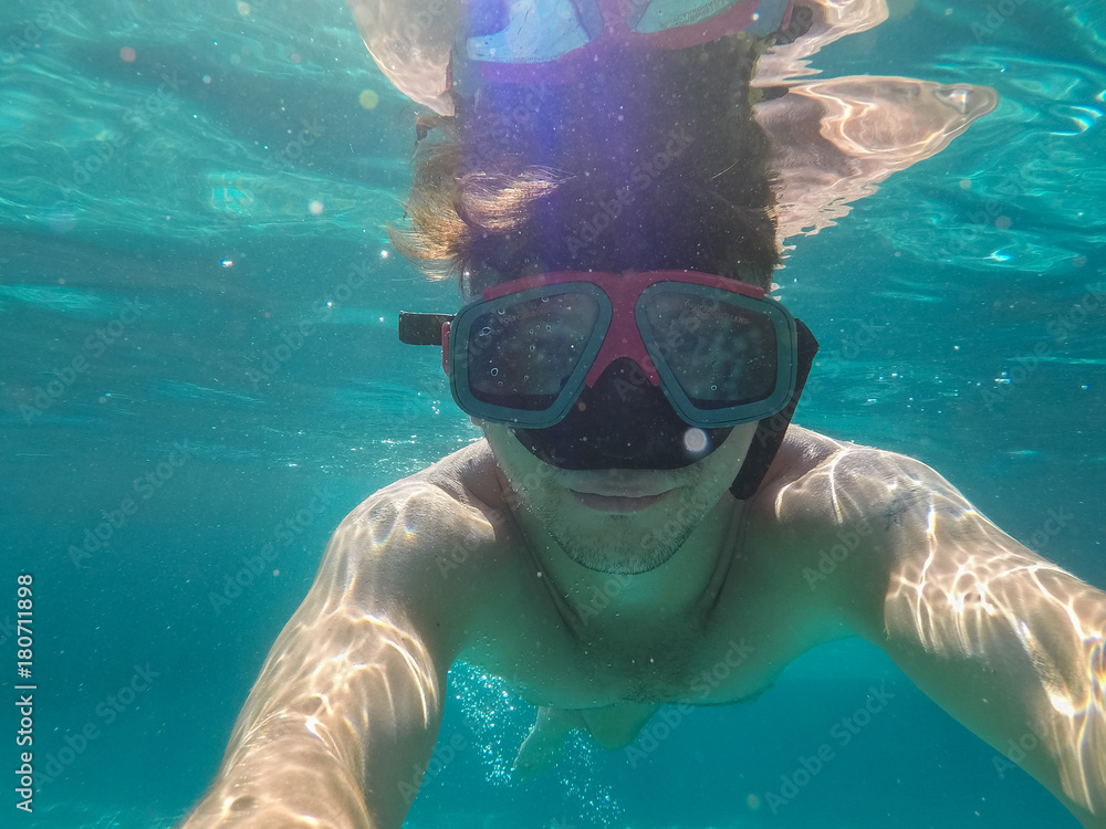 Fototapeta premium The man with the underwater mask is engaged in diving