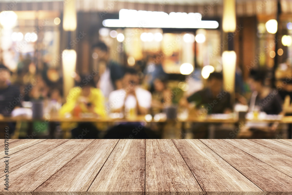 Wood table top with blurred light cafe or restaurant background 