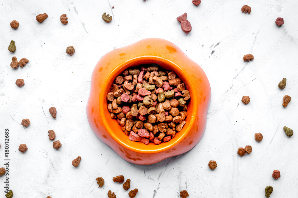 dry cat food in bowl on stone background top view dry cat food in bowl on stone background top view