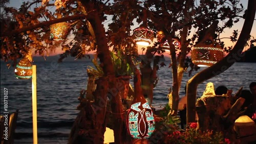 Decorative gourd hanging in a tree at a beach side restaurant in the evening