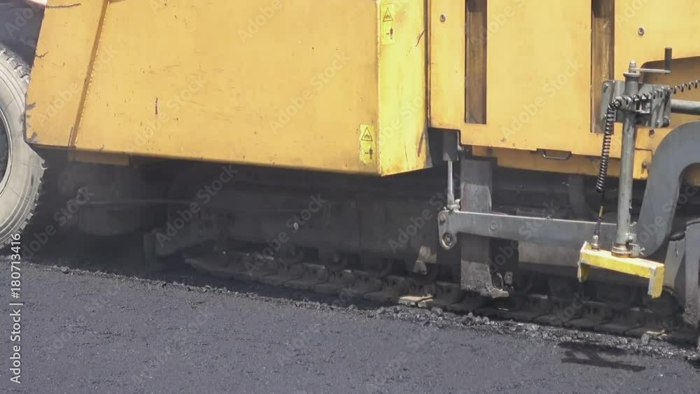 Road construction. Applying new hot asphalt using road construction machinery and power industrial tools. Roadworks repaving process. Road construction. Applying new hot asphalt using road construction machinery and power industrial tools. Roadworks repaving process.