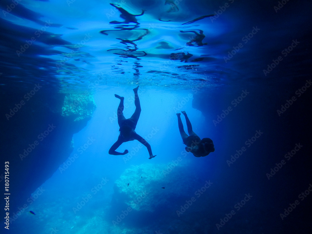 Fototapeta premium Two persons dive into the blue water