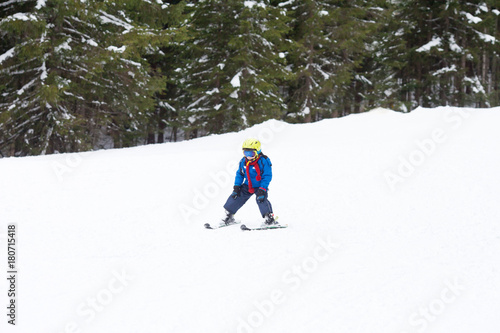 Young child, skiing on snow slope in ski resort in Austria
