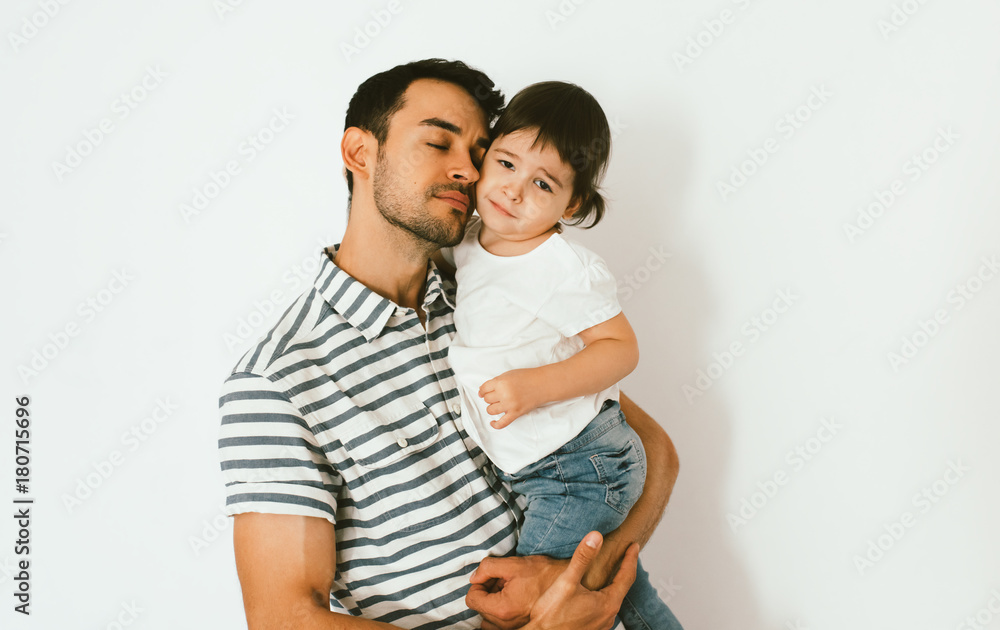 Dad's support of sad daughter cuddle together against white background. Good and affectionate relationship of parent and child. Family moments of father and toddler girl. Childhood and parenthood care Dad's support of sad daughter cuddle together against white background. Good and affectionate relationship of parent and child. Family moments of father and toddler girl. Childhood and parenthood care