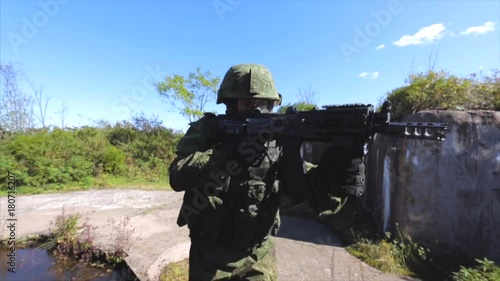 Soldier on tactical maneuvers. Soldier with automatic rifle and uniform. Old military object photo