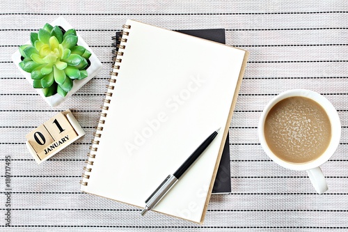 Business, weekend, holiday or new year planning concept : Top view or flat lay of open notebook paper, cube calendar and coffee cup on table background, ready for adding or mock up
