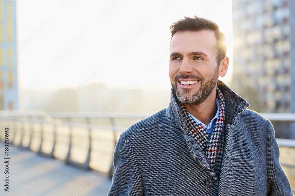 Happy man standing outdoors during sunny winter day - obrazy, fototapety, plakaty 