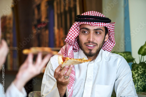 Photography Young muslim guy having pizza