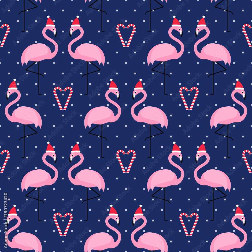 Obraz premium Flamingo in xmas hat with candy cane heart seamless pattern on blue polka dots background. Exotic New Year background. Christmas design for fabric, wallpaper, textile and decor.
