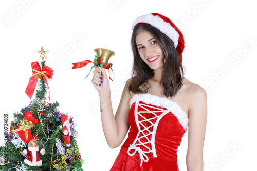 Christmas concept : Beautiful young Asian woman in Santa Claus costume holding handbell with decorated Christmas tree isolated on white background