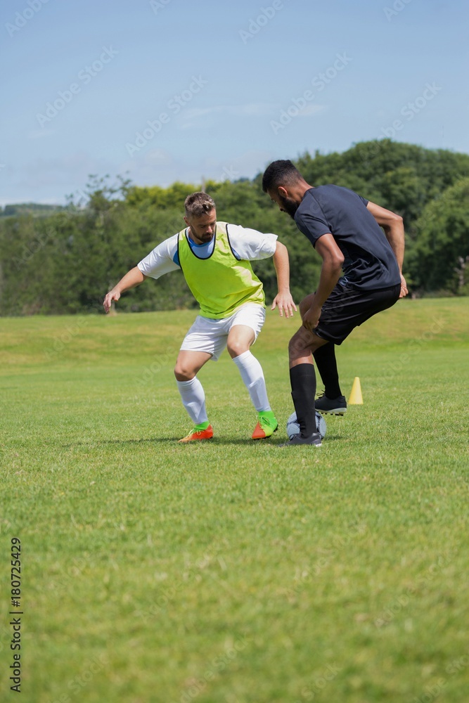 Football players dribbling the soccer on the football ground