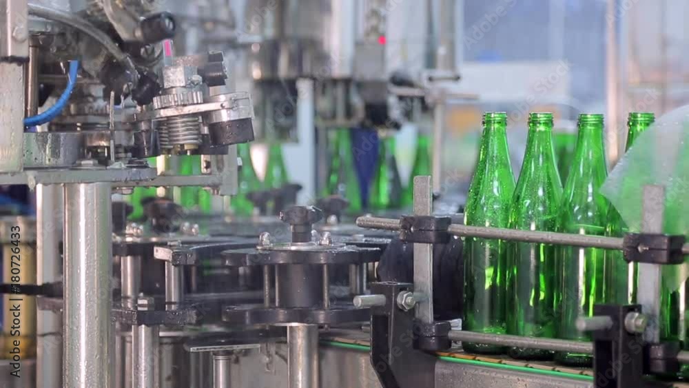 Line of water production. Green glass bottles move along the line, they are automatically rinsed before filling with water Line of water production. Green glass bottles move along the line, they are automatically rinsed before filling with water