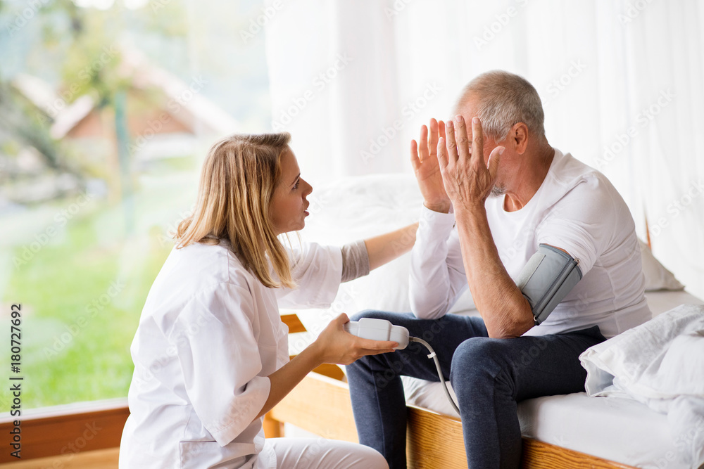 Health visitor and a senior man during home visit. Health visitor and a senior man during home visit.