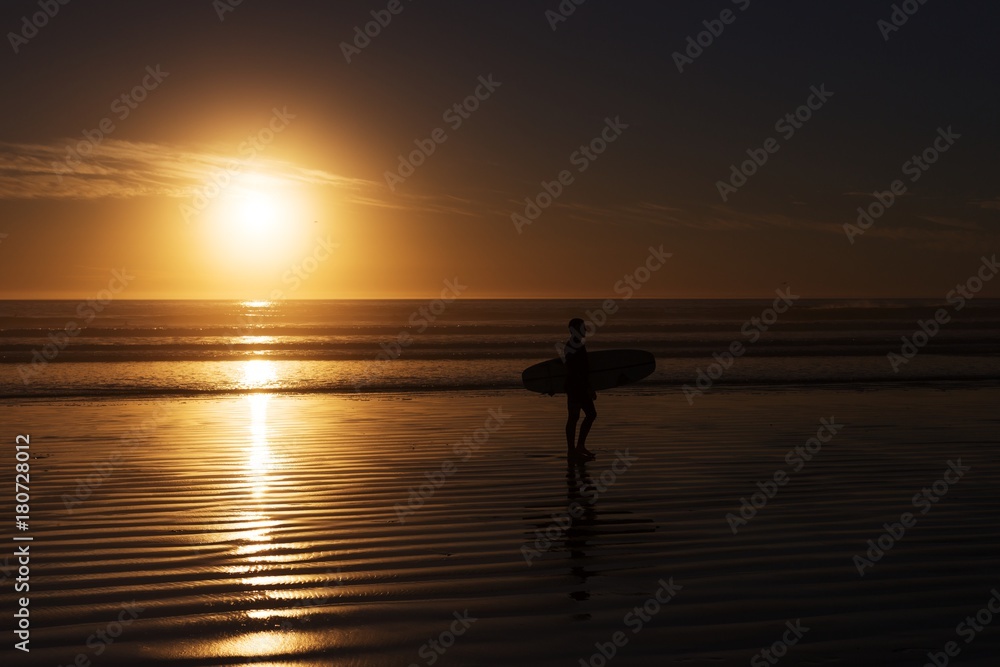 surfer with surfboard silhouette at the sunset beach