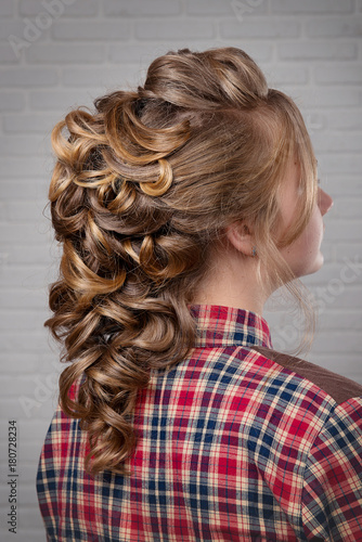 Women's hairstyle halo braid on the hair of the brown-haired rear view of the head turning to the right on a light background