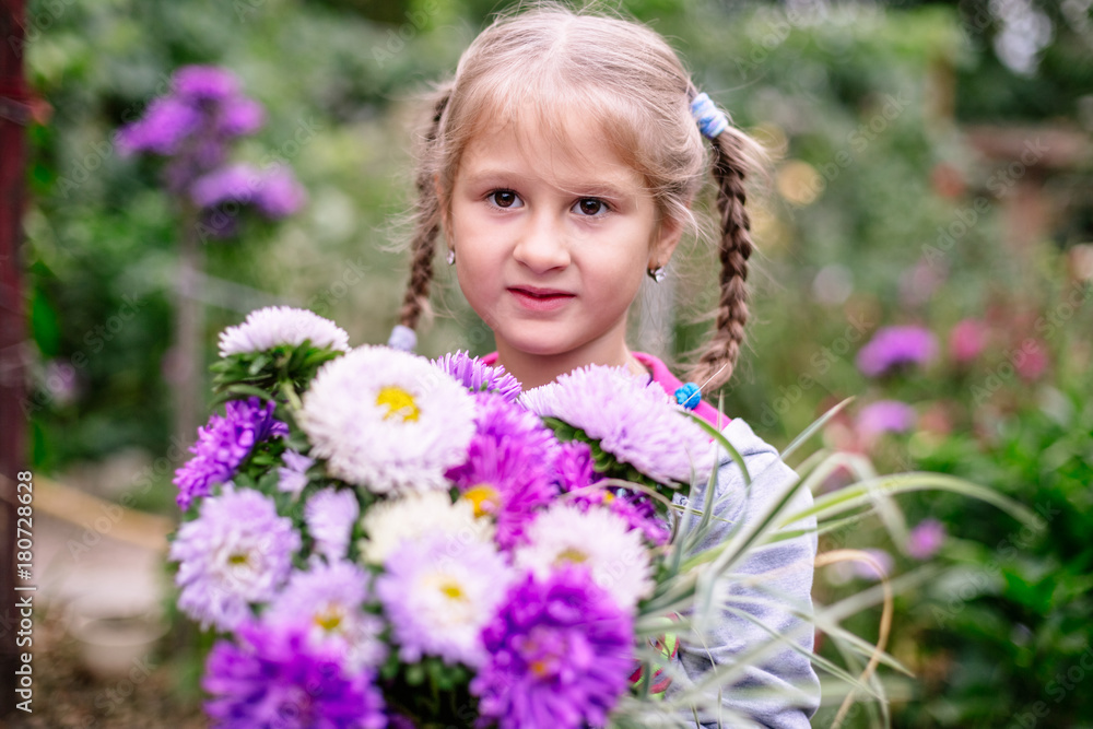 Fototapeta premium Little girl with a bouquet of flowers.