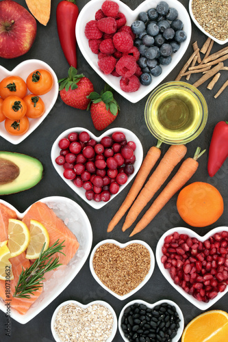 Fototapeta Naklejka Na Ścianę i Meble -  Health food for a healthy heart with berry fruit, vegetables, seeds, pulses, cereal and olive oil on slate background. High in omega 3 fatty acid and antioxidants.