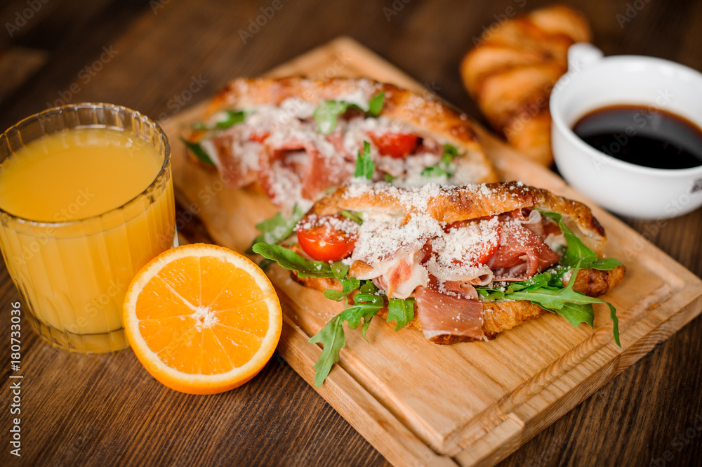 Tasty breakfast consisting of burger with ham bone, cherry tomatoes and arugula Tasty breakfast consisting of burger with ham bone, cherry tomatoes and arugula