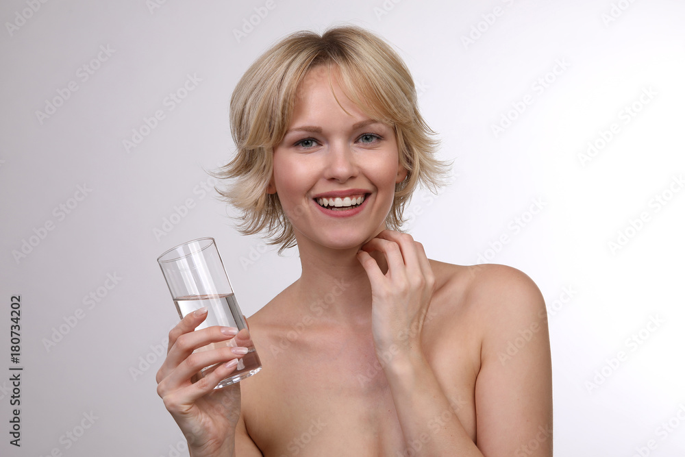 Hübsche blonde Frau mit einem Glas Wasser lacht Hübsche blonde Frau mit einem Glas Wasser lacht