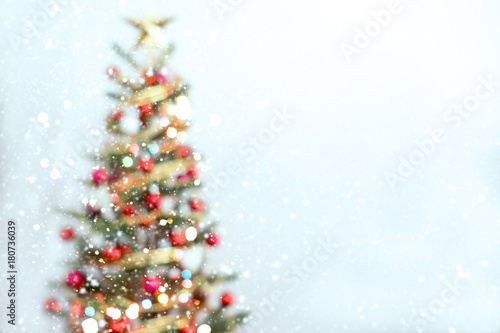 Blurred of Christmas tree and light bokeh with snowfall on winter background