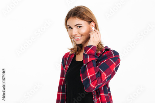 Cheerful young woman listening music with earphones. © Drobot Dean