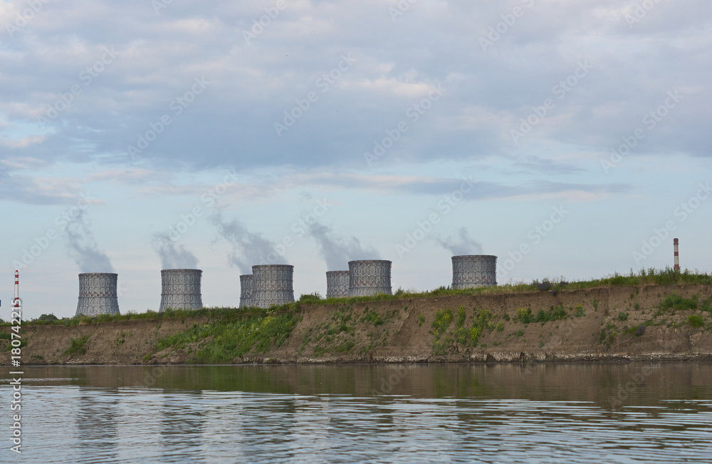 Cooling towers of a nuclear power plant on the river bank.