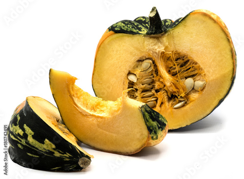 One spotty green yellow pumpkin half with fresh meat and seeds, two slices isolated on white background. photo