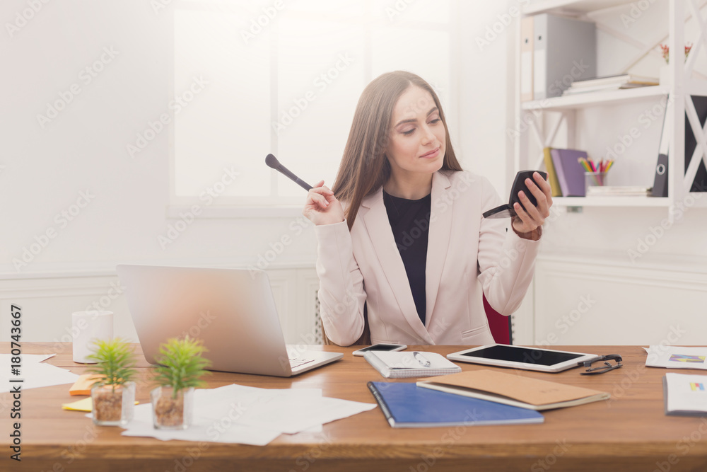 Business woman refreshing her makeup at office Business woman refreshing her makeup at office