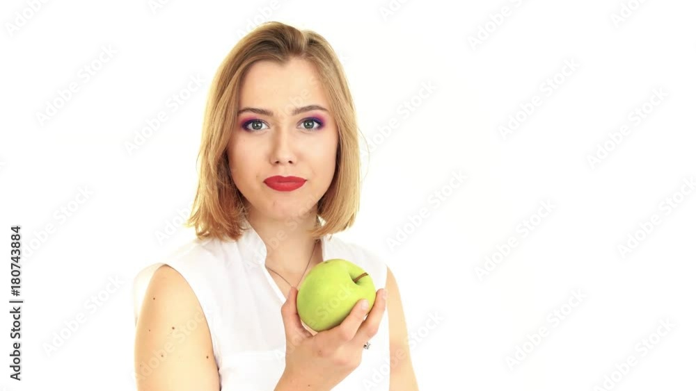 A young woman takes a bite of an apple. Video on white background A young woman takes a bite of an apple. Video on white background