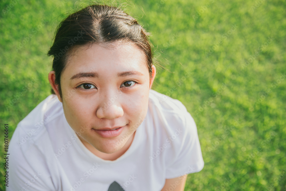 cute young innocent asian teen smile with green grass background closeup head and face cute young innocent asian teen smile with green grass background closeup head and face