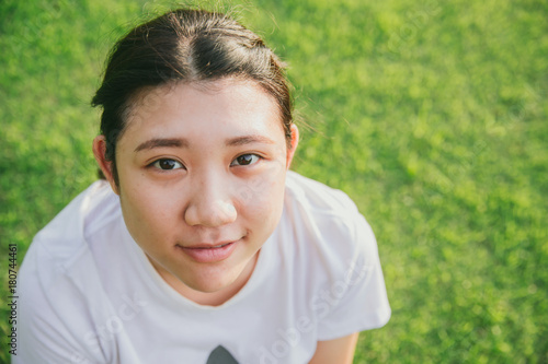 cute young innocent asian teen smile with green grass background closeup head and face