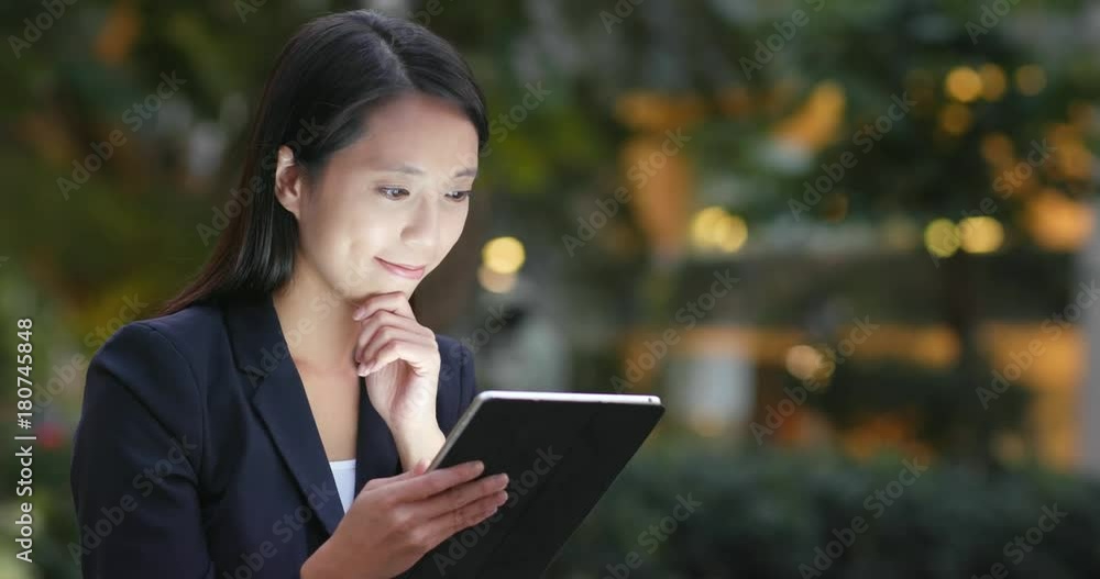 Businesswoman looking at tablet computer at night