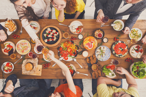 Happy people eat healthy meals at served table dinner party
