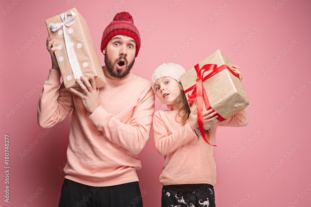 Portrait of a surprised little girl with her father holding a Christmas present Portrait of a surprised little girl with her father holding a Christmas present