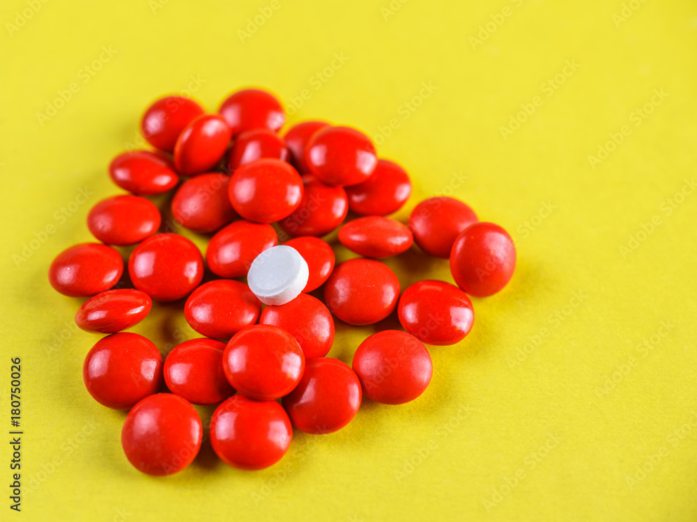 bright red pills on a yellow background. bright red pills on a yellow background.