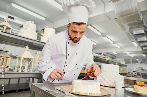 A confectioner with a cake in the bakery. photo